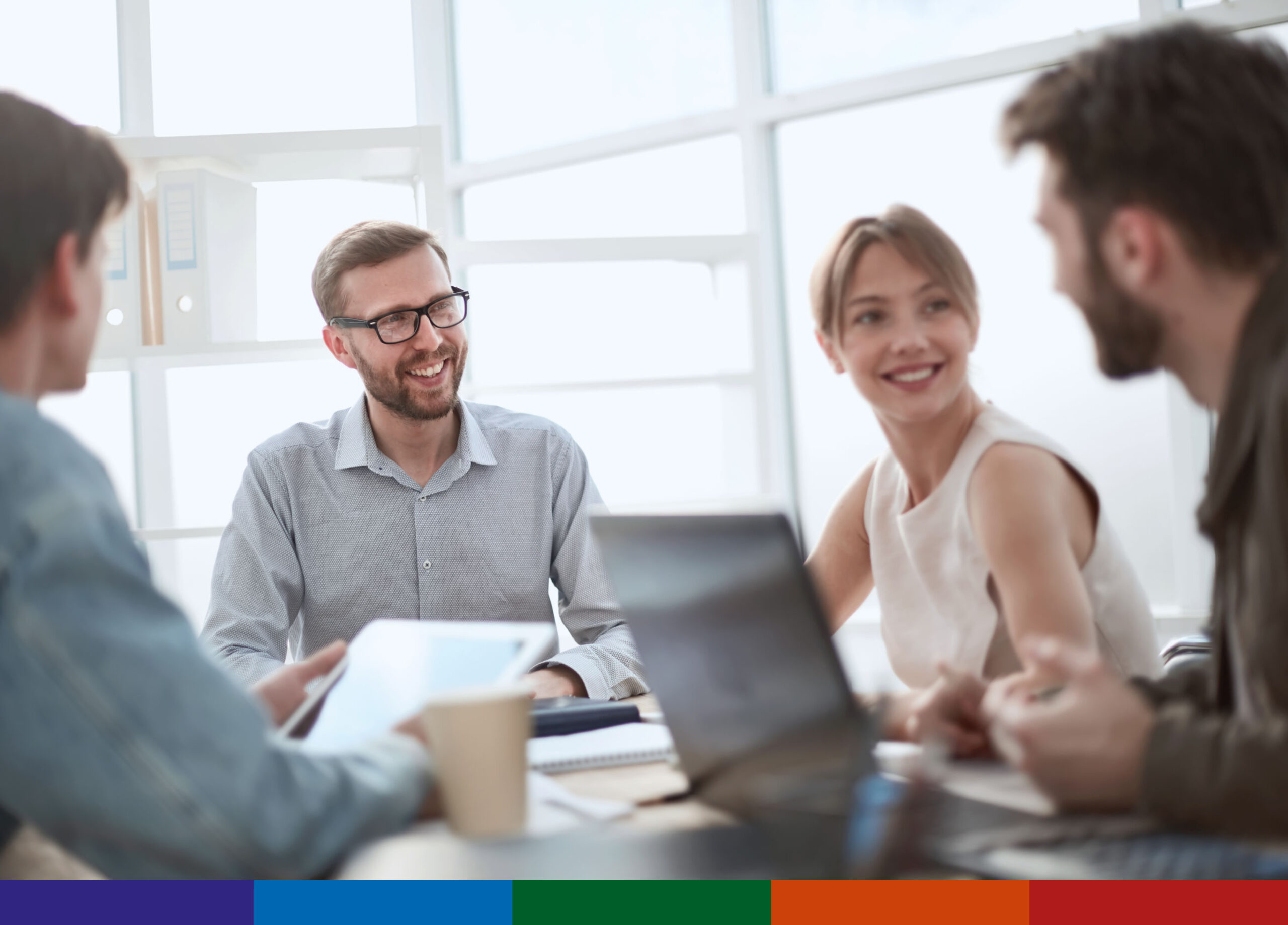 Group of colleagues in an office environment having a candid meeting