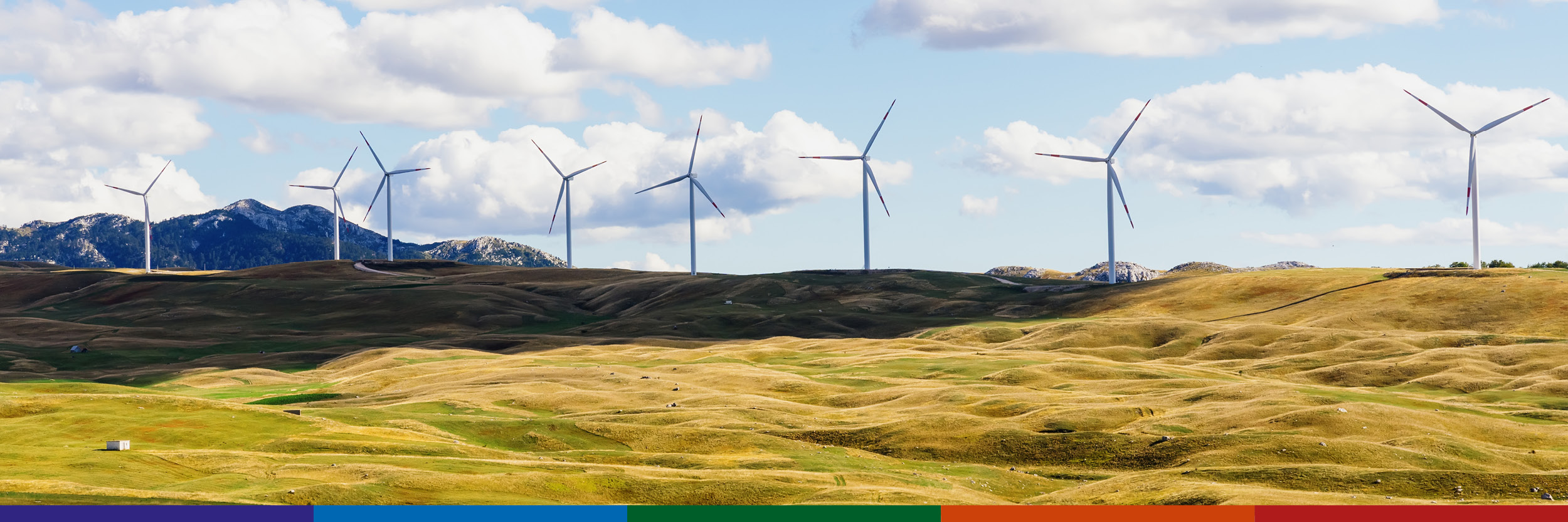 Image of wind turbines in operation on hillside.