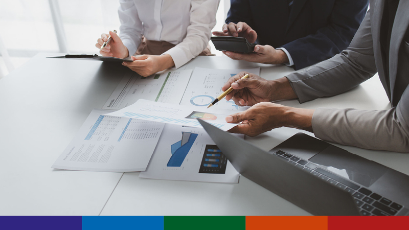 Image of colleagues looking at documents and laptop