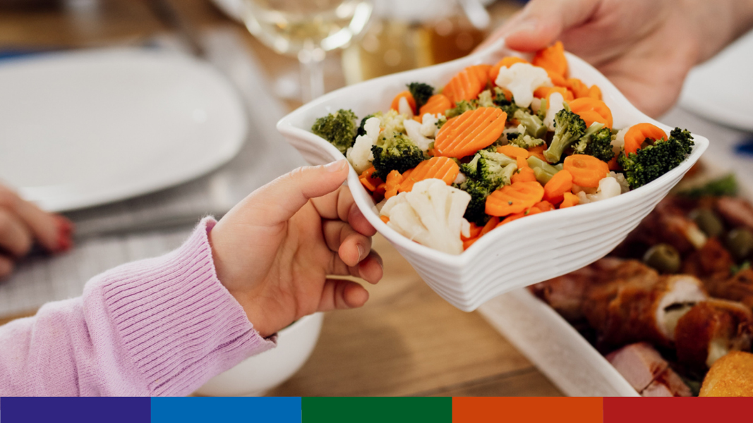 Adult and child holding a bowl of vegetables