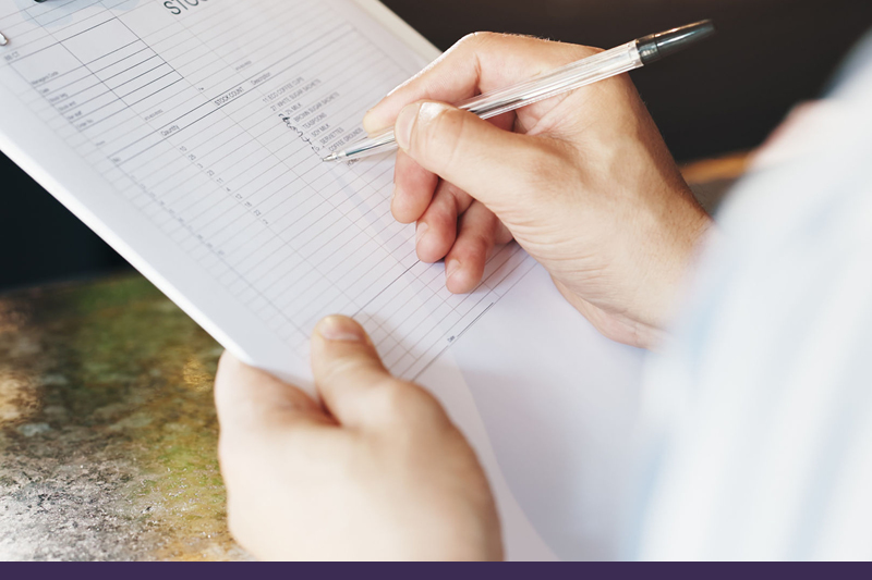 Image of someone writing on a report