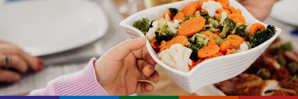 Child being handed bowl of vegetables