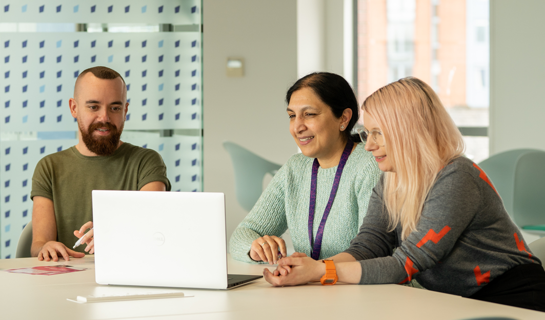 diverse collegues working at a laptop